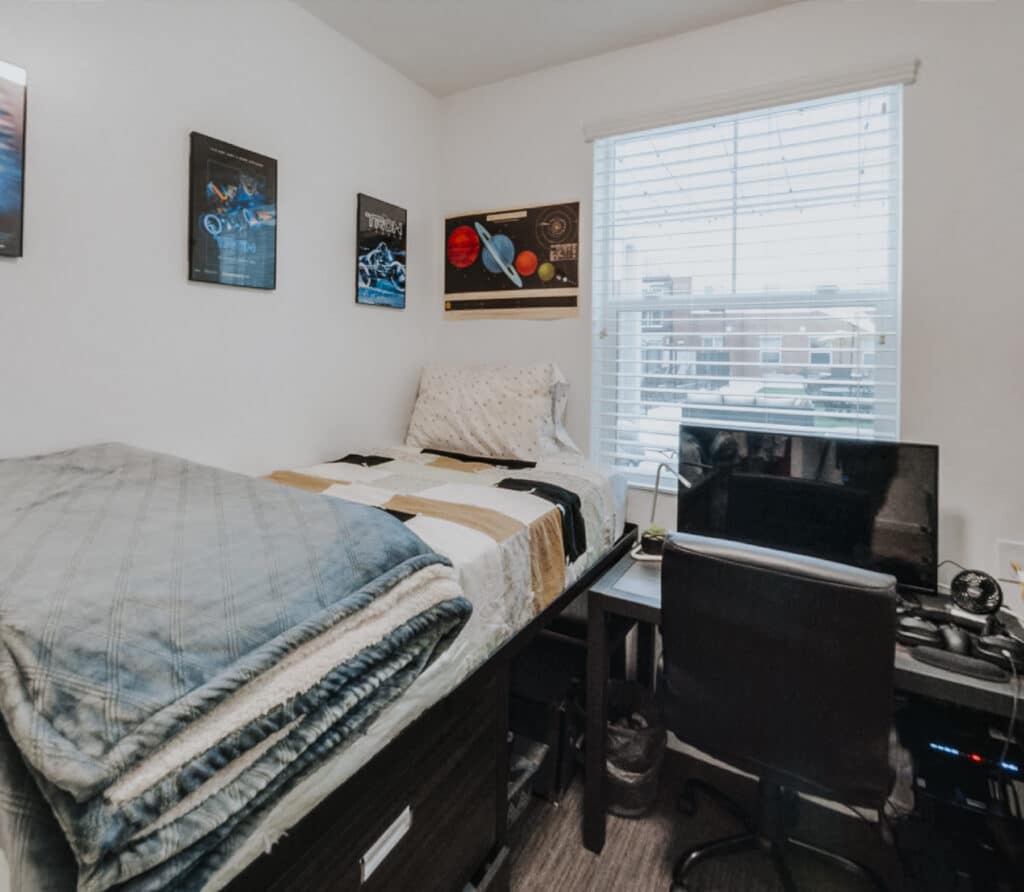Furnished student bedroom with desk and full-size bed at Vintage at Tabernacle