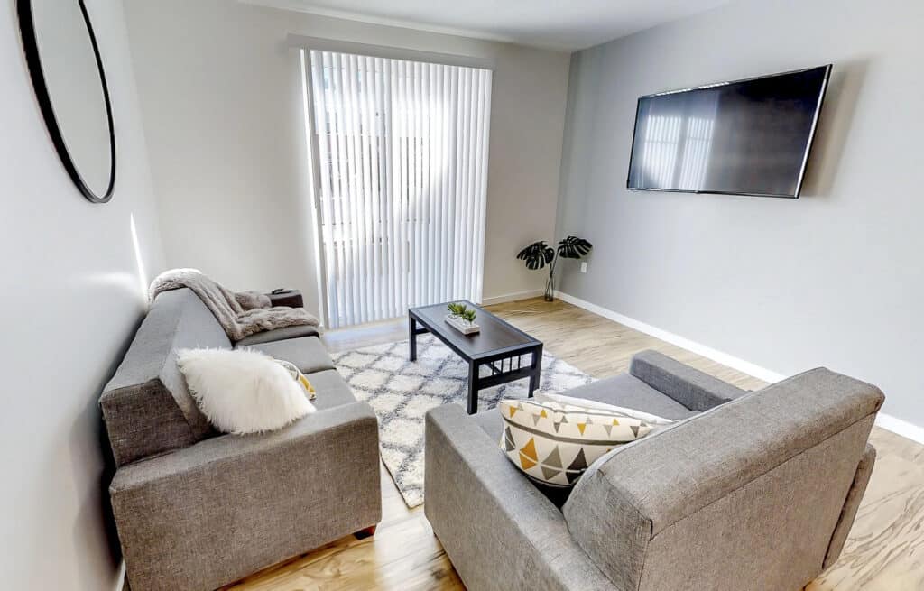 Furnished living room with sectional seating and wall-mounted TV at Vintage at Tabernacle